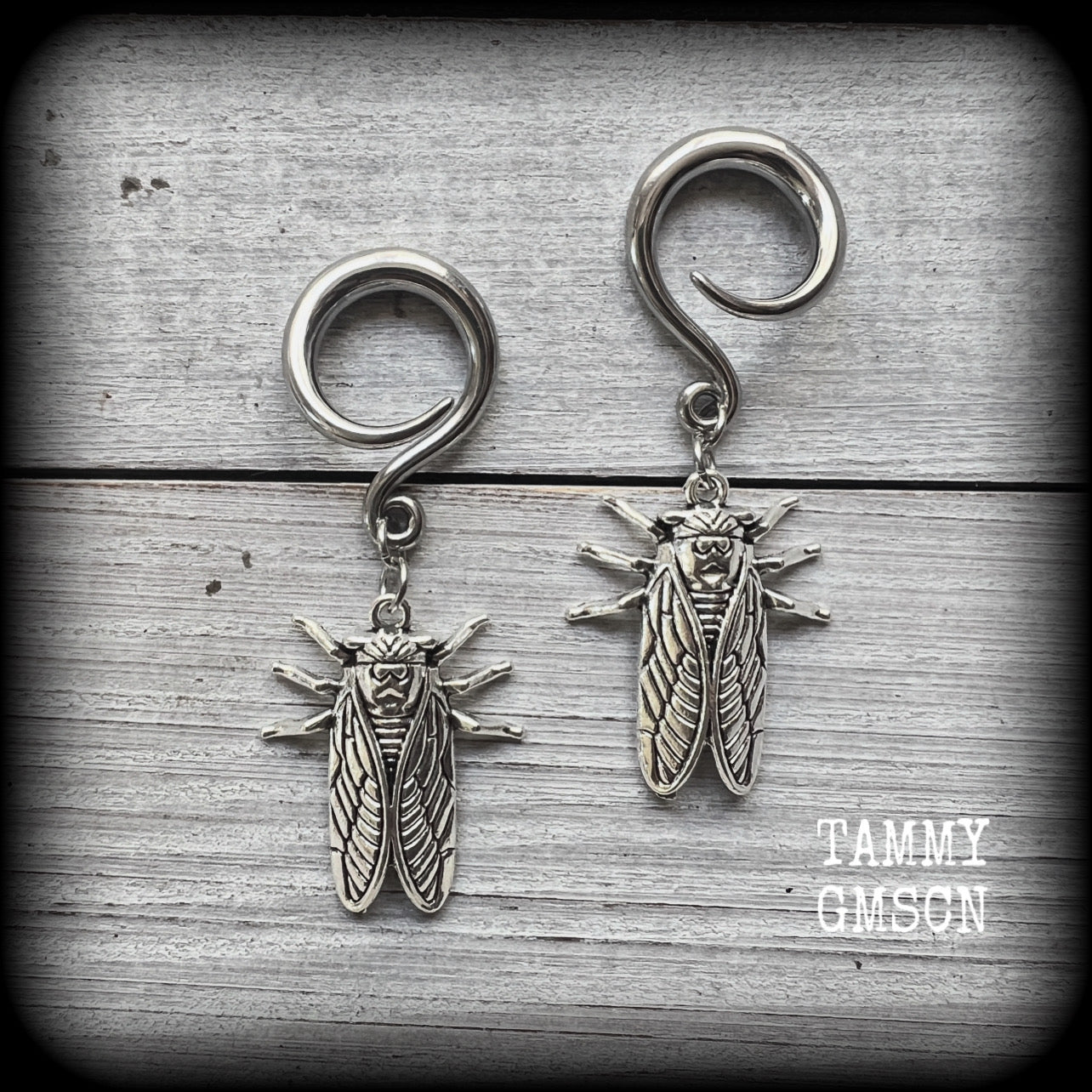 These adorable insect gauged earrings feature an antique silver cicada, nice and dangly measuring just under 6cms from tip to tip, and weighing approx 7 grams each.
This pair has been made on 6 gauge (4mm) surgical steel full curl hooks, suitable for stretched lobes.