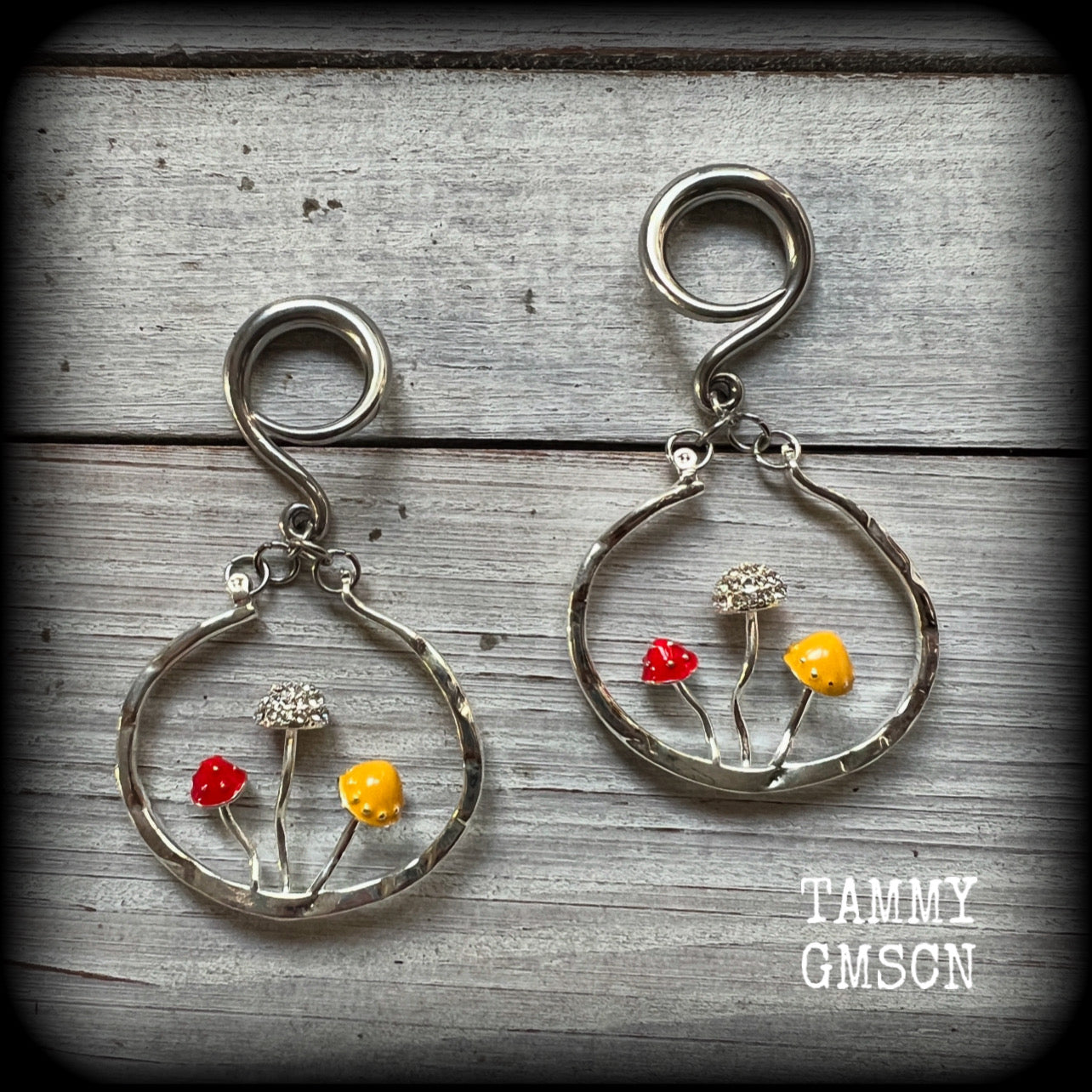 Inspired by Alice in Wonderland, these antique silver and enamel mushroom hoop gauged earrings are just gorgeous, weighing in at 10 grams a piece, and nice and dangly at just under 7cms.

This pair has been made on 6 gauge (4mm) surgical steel full curl hooks, to be worn in stretched lobes.