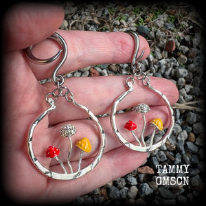 Inspired by Alice in Wonderland, these antique silver and enamel mushroom hoop gauged earrings are just gorgeous, weighing in at 10 grams a piece, and nice and dangly at just under 7cms.
This pair has been made on 6 gauge (4mm) surgical steel full curl hooks, to be worn in stretched lobes.