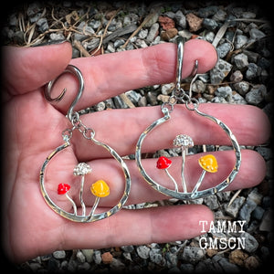 Inspired by Alice in Wonderland, these antique silver and enamel mushroom hoop gauged earrings are just gorgeous, weighing in at 10 grams a piece, and nice and dangly at just under 7cms.

This pair has been made on 6 gauge (4mm) surgical steel full curl hooks, to be worn in stretched lobes.