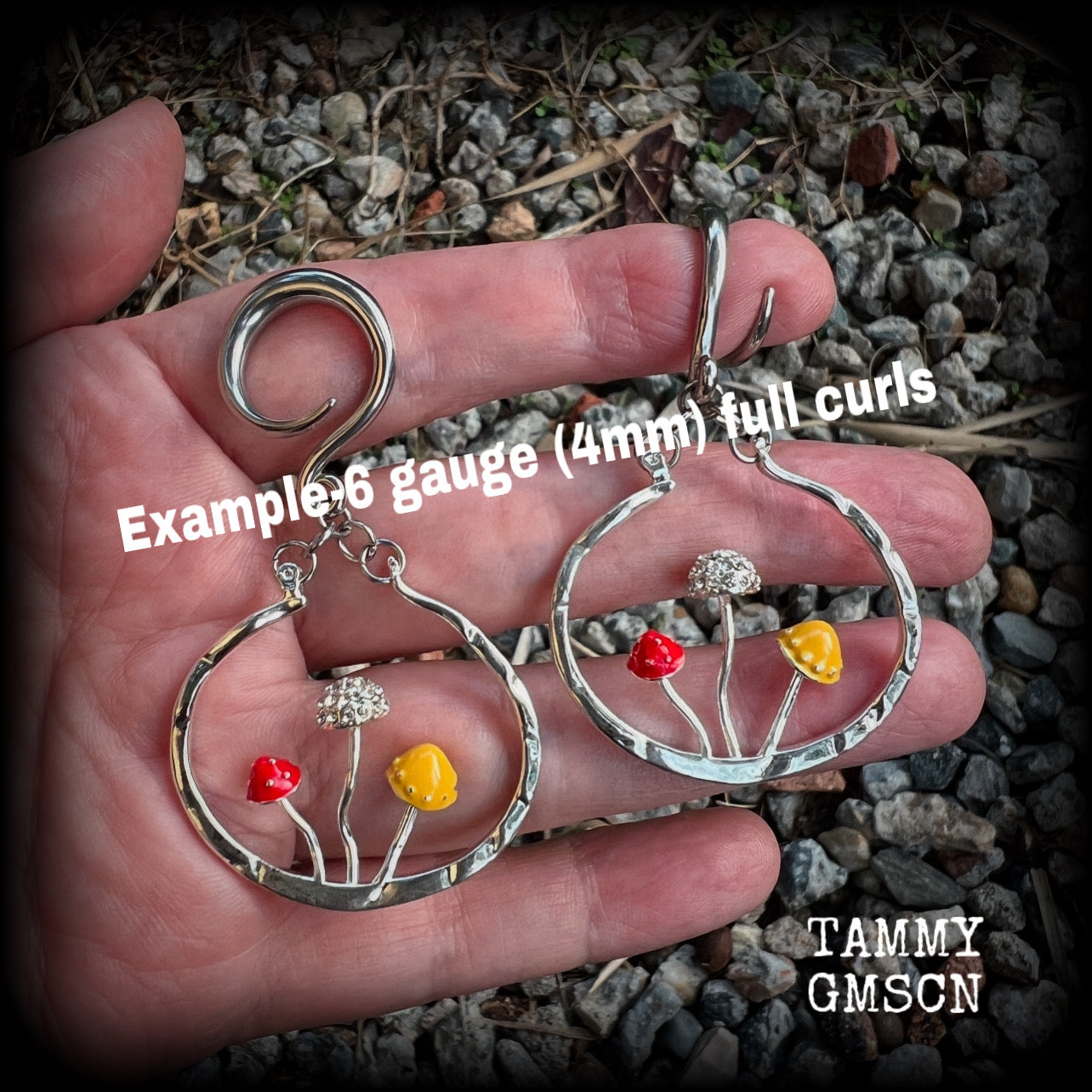 Inspired by Alice in Wonderland, these antique silver and enamel mushroom hoop ear hangers are lovely and light weight at 14 grams a piece, and nice and dangly at just on 8cms from tip to tip.
This pair has been made on 6 gauge surgical steel full curls to be worn in stretched lobes.