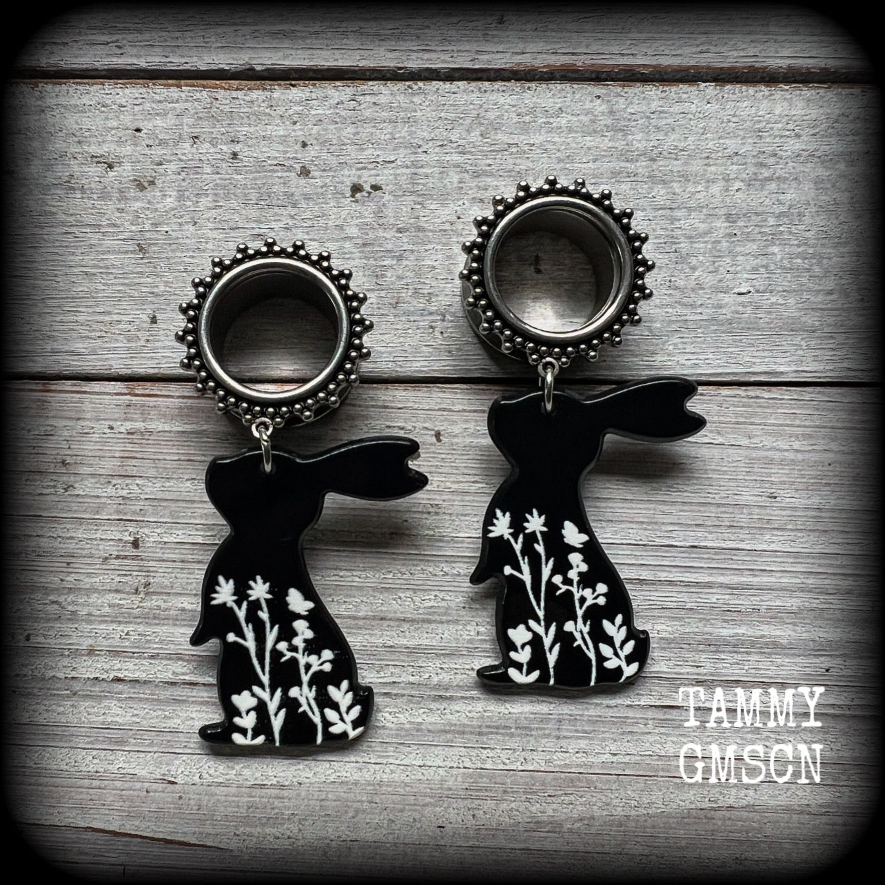 Featuring a black rabbit silhouette looking skyward with white floral sprig, these earrings weigh only 8 grams each and measure approx 6 from tip to tip. This pair has been made on 5/8” gauge (16mm) ornate surgical steel screw fit tunnels.
