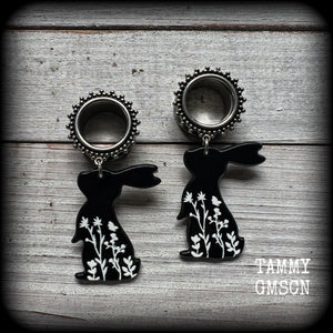 Featuring a black rabbit silhouette looking skyward with white floral sprig, these earrings weigh only 8 grams each and measure approx 6 from tip to tip. This pair has been made on 5/8” gauge (16mm) ornate surgical steel screw fit tunnels.
