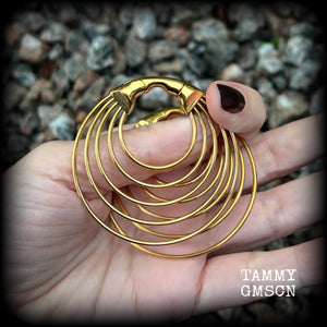 These gorgeous gold hoop gauged earrings feature beautiul titanium coated surgical steel stacked hoops, measuring just under 6cms from tip to tip, and weighing approx 13 grams each.

These are suitable to be worn in stretched lobes from 4 gauge (5mm), and will fit in earlets and tunnels in stretched lobes from 2 gauge (6mm).
