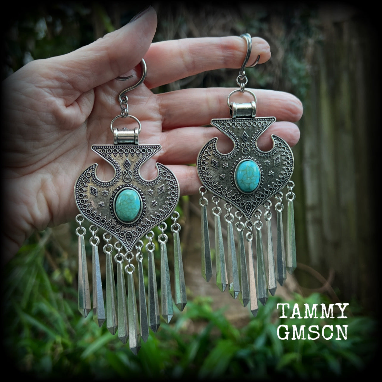 Inspired by Hathor, these unique ethnic inspired gauged earrings feature gorgeous antique silver pendants with beautiful turquoise stones.
These are gorgeous statement ear hangers, measuring just under 15cms from tip to tip and weighing in at 45 grams each they do have a nice bit of weight to them.

This pair has been made on 6 gauge (4mm) surgical steel full curl hooks, to be worn in stretched lobes.