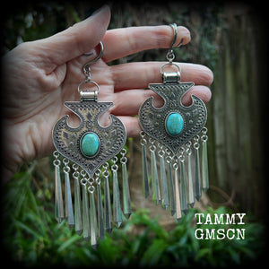 Inspired by Hathor, these unique ethnic inspired gauged earrings feature gorgeous antique silver pendants with beautiful turquoise stones.
These are gorgeous statement ear hangers, measuring just under 15cms from tip to tip and weighing in at 45 grams each they do have a nice bit of weight to them.

This pair has been made on 6 gauge (4mm) surgical steel full curl hooks, to be worn in stretched lobes.