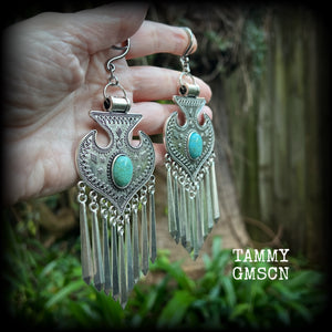 Inspired by Hathor, these unique ethnic inspired gauged earrings feature gorgeous antique silver pendants with beautiful turquoise stones.
These are gorgeous statement ear hangers, measuring just under 15cms from tip to tip and weighing in at 45 grams each they do have a nice bit of weight to them.

This pair has been made on 6 gauge (4mm) surgical steel full curl hooks, to be worn in stretched lobes.