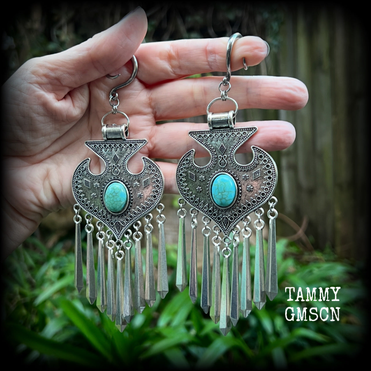 Inspired by Hathor, these unique ethnic inspired gauged earrings feature gorgeous antique silver pendants with beautiful turquoise stones.
These are gorgeous statement ear hangers, measuring just under 15cms from tip to tip and weighing in at 45 grams each they do have a nice bit of weight to them.

This pair has been made on 6 gauge (4mm) surgical steel full curl hooks, to be worn in stretched lobes.