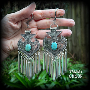 Inspired by Hathor, these unique ethnic inspired gauged earrings feature gorgeous antique silver pendants with beautiful turquoise stones.
These are gorgeous statement ear hangers, measuring just under 15cms from tip to tip and weighing in at 45 grams each they do have a nice bit of weight to them.

This pair has been made on 6 gauge (4mm) surgical steel full curl hooks, to be worn in stretched lobes.
