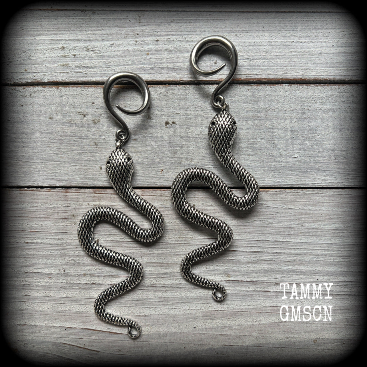 These awesome gauged earrings feature an antique silver snake, nice and dangly measuring just on 10cms from tip to tip, and weighing approx 14 grams each.
This pair has been made on 6 gauge (4mm) surgical steel full curl hooks, suitable for stretched lobes.