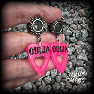 These adorable spooky tunnel dangles feature sparkly pink acrylic ouija board planchettes, are are nice and lightweight, weighing approx 6 grams each, measuring approx 5cms from tip to tip.

This pair has been made with 00 gauge (10mm) gauge ornate surgical steel screw fit tunnels, for stretched lobes.