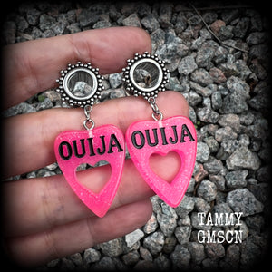 These adorable spooky tunnel dangles feature sparkly pink acrylic ouija board planchettes, are are nice and lightweight, weighing approx 6 grams each, measuring approx 5cms from tip to tip.

This pair has been made with 00 gauge (10mm) gauge ornate surgical steel screw fit tunnels, for stretched lobes.