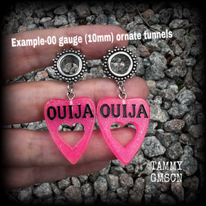 These adorable spooky tunnel dangles feature sparkly pink acrylic ouija board planchettes, are are nice and lightweight, weighing approx 6 grams each, measuring approx 5cms from tip to tip.

This pair has been made with 00 gauge (10mm) gauge ornate surgical steel screw fit tunnels, for stretched lobes.