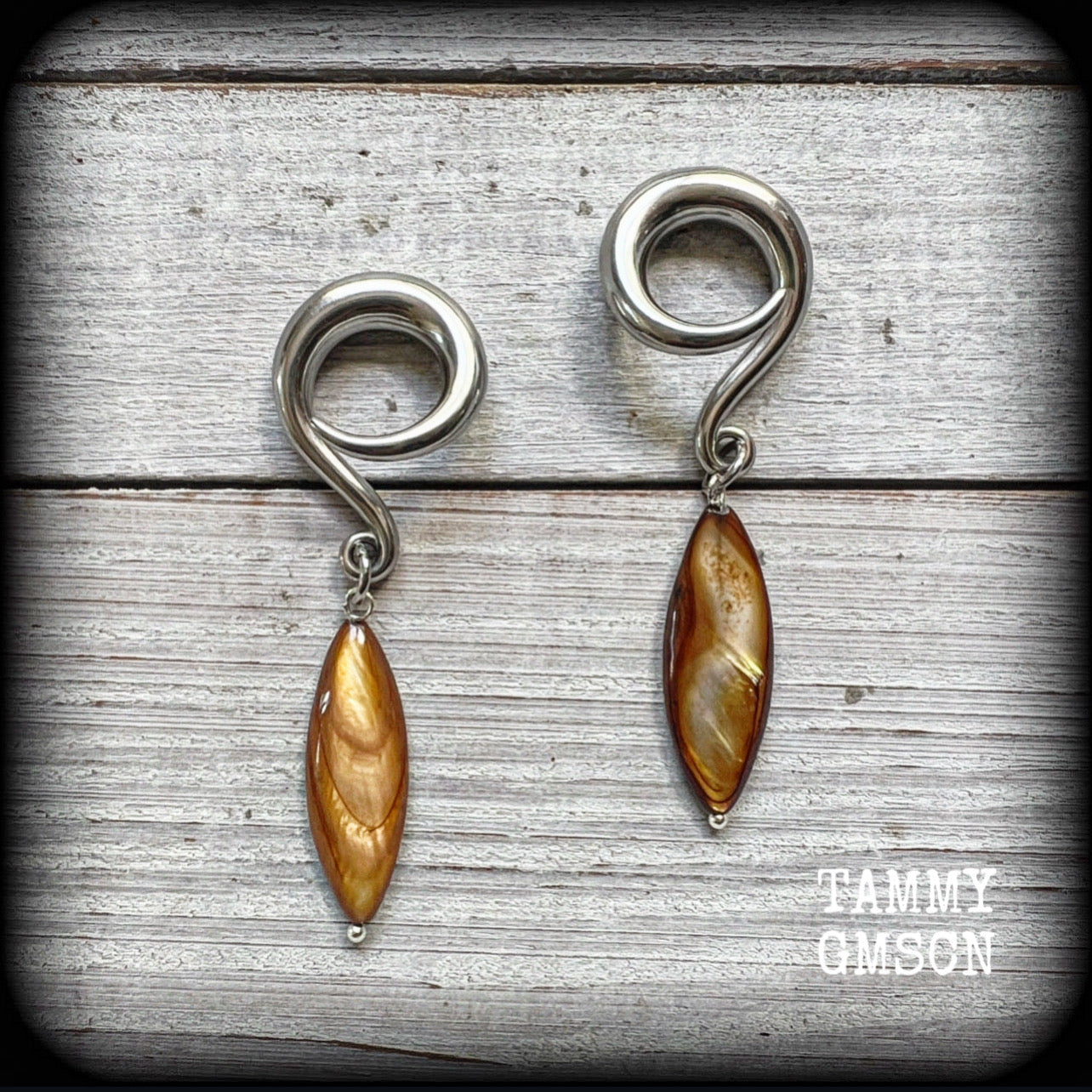 These gorgeous gauged earrings feature beautiful polished sea shell slivers, weighing in approx 10 grams a piece, and measuring approx 7cms from tip to tip.
This pair has been made on 2 gauge (6mm) surgical steel full curl hooks, to be worn in stretched lobes.