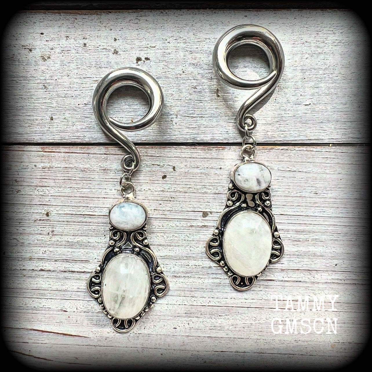 These gorgeous gemstone earrings feature beautiful big rainbow moonstones in a beautiful antique silver setting. 
These earrings are lovely and dangly measuring approx 8 from tip to tip, and weighing approx 14 grams each.
This pair have been made on 2 gauge (6mm) surgical steel full curl hooks, suitable for stretched lobes.