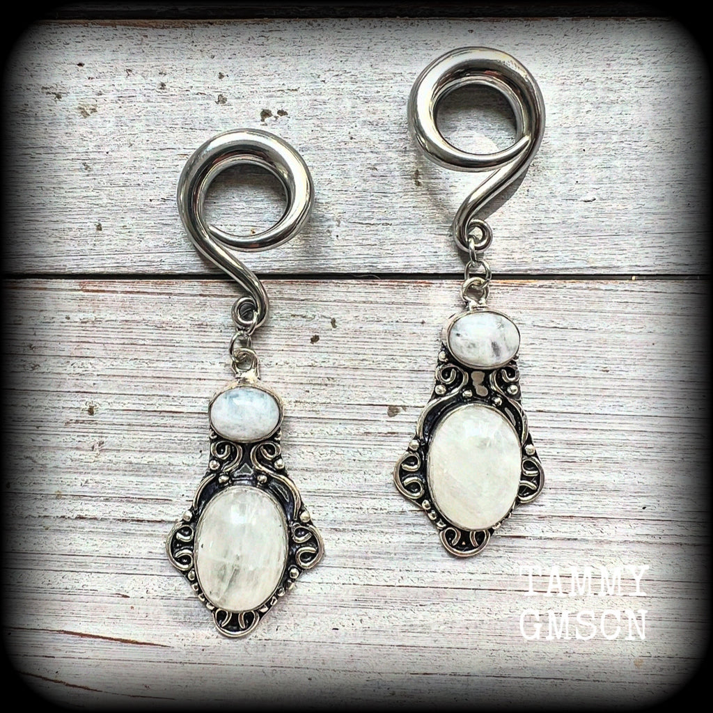 These gorgeous gemstone earrings feature beautiful big rainbow moonstones in a beautiful antique silver setting. 
These earrings are lovely and dangly measuring approx 8 from tip to tip, and weighing approx 14 grams each.
This pair have been made on 2 gauge (6mm) surgical steel full curl hooks, suitable for stretched lobes.