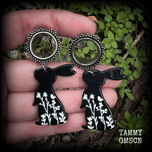 Featuring a black rabbit silhouette looking skyward with white floral sprig, these earrings weigh only 8 grams each and measure approx 6 from tip to tip. This pair has been made on 5/8” gauge (16mm) ornate surgical steel screw fit tunnels.