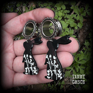 Featuring a black rabbit silhouette looking skyward with white floral sprig, these earrings weigh only 8 grams each and measure approx 6 from tip to tip. This pair has been made on 5/8” gauge (16mm) ornate surgical steel screw fit tunnels.