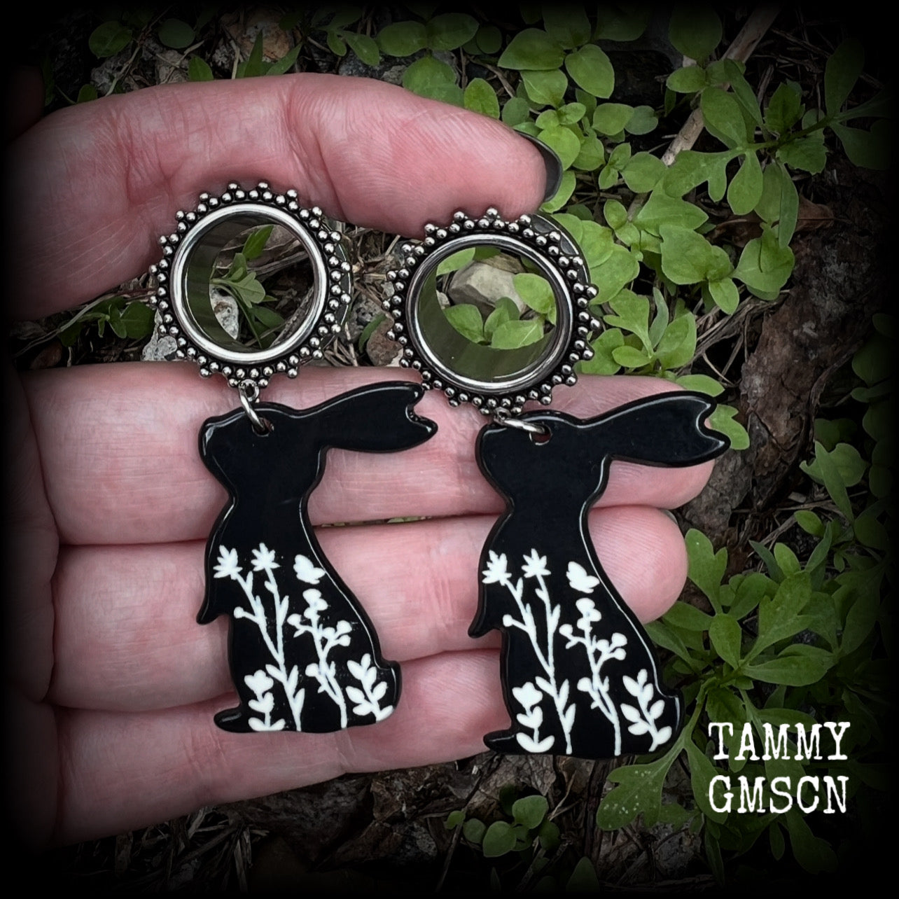 Featuring a black rabbit silhouette looking skyward with white floral sprig, these earrings weigh only 8 grams each and measure approx 6 from tip to tip. This pair has been made on 5/8” gauge (16mm) ornate surgical steel screw fit tunnels.