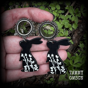 Featuring a black rabbit silhouette looking skyward with white floral sprig, these earrings weigh only 8 grams each and measure approx 6 from tip to tip. This pair has been made on 5/8” gauge (16mm) ornate surgical steel screw fit tunnels.