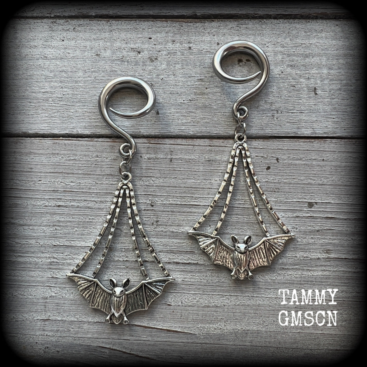 Featuring gorgeous light weight gothic silver bat charms, these spooky cute gauged earrings weigh in at 7 grams a piece, and measure just over 7cms from tip to tip.

This pair has been made on 6 gauge (4mm) surgical steel full curl hooks, to be worn in stretched lobes.