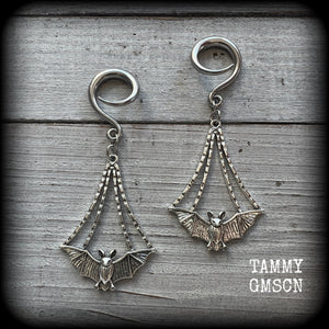 Featuring gorgeous light weight gothic silver bat charms, these spooky cute gauged earrings weigh in at 7 grams a piece, and measure just over 7cms from tip to tip.

This pair has been made on 6 gauge (4mm) surgical steel full curl hooks, to be worn in stretched lobes.