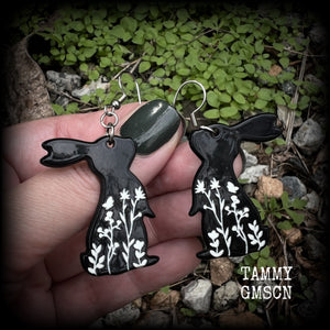 Featuring a black rabbit silhouette looking skyward with white floral sprig, these earrings are nice and lightweight, weighing only a few grams each and measure approx 6 from tip to tip. This pair has made on stainless steel french hooks.