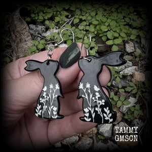 Featuring a black rabbit silhouette looking skyward with white floral sprig, these earrings are nice and lightweight, weighing only a few grams each and measure approx 6 from tip to tip. This pair has made on stainless steel french hooks.