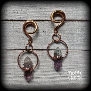 Featuring a pair of beatifully rustic purple fluorite points in an antique copper setting, these gauged earrings measure just over 8cms from tip to tip, and weigh approx 13 grams each.
This pair has been made on 2 gauge (6mm) surgical steel full curl hooks, suitable for stretched lobes.