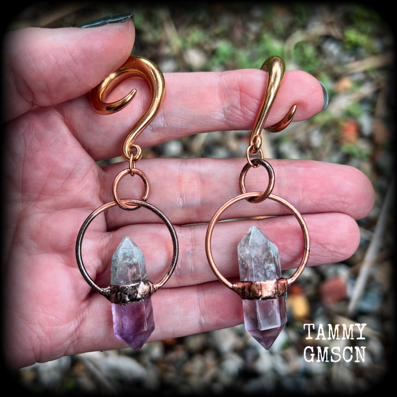 Featuring a pair of beatifully rustic purple fluorite points in an antique copper setting, these gauged earrings measure just over 8cms from tip to tip, and weigh approx 13 grams each.
This pair has been made on 2 gauge (6mm) surgical steel full curl hooks, suitable for stretched lobes.