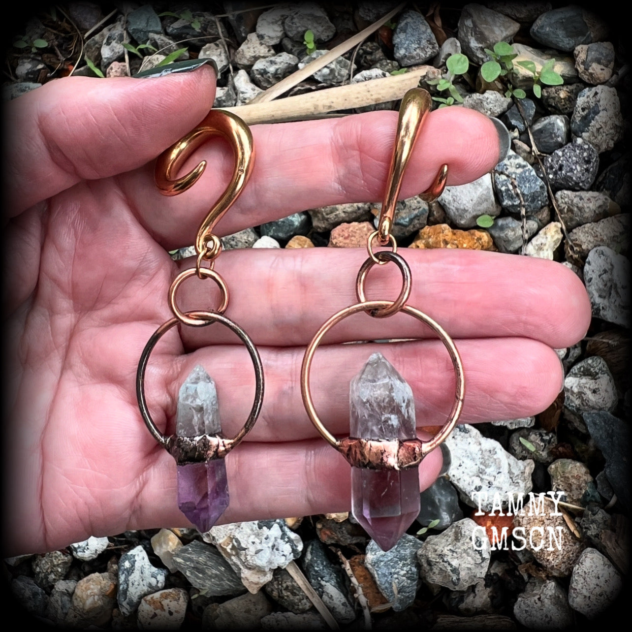 Featuring a pair of beatifully rustic purple fluorite points in an antique copper setting, these gauged earrings measure just over 8cms from tip to tip, and weigh approx 13 grams each.
This pair has been made on 2 gauge (6mm) surgical steel full curl hooks, suitable for stretched lobes.
