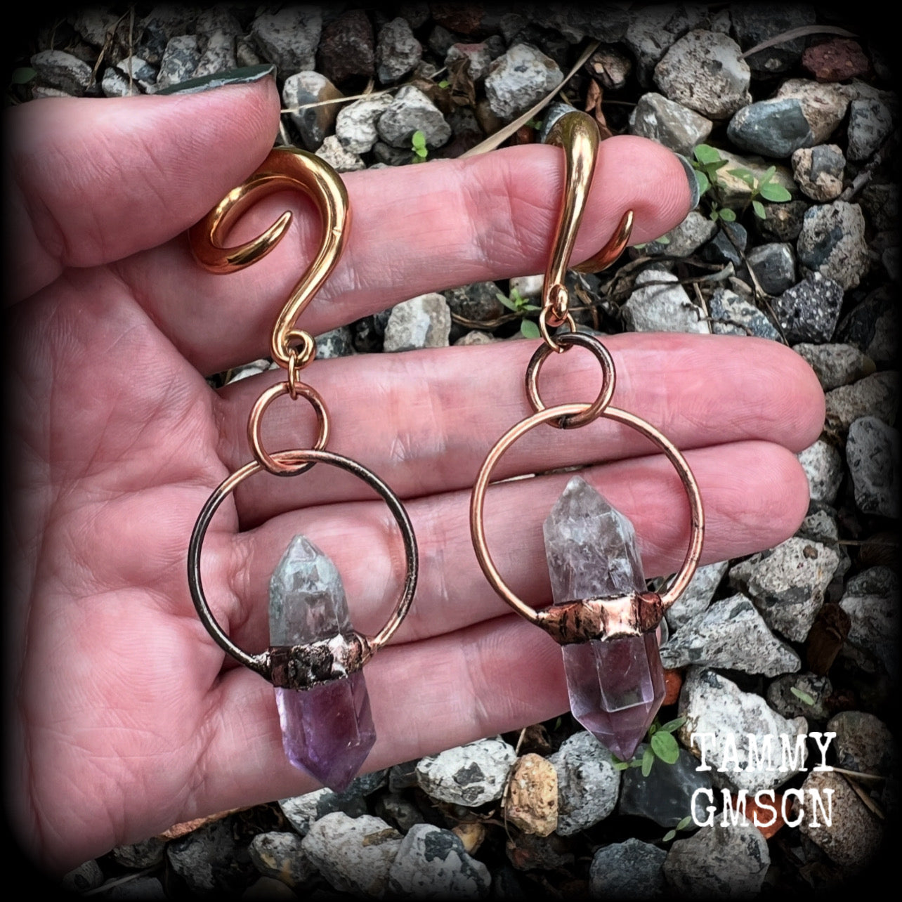 Featuring a pair of beatifully rustic purple fluorite points in an antique copper setting, these gauged earrings measure just over 8cms from tip to tip, and weigh approx 13 grams each.
This pair has been made on 2 gauge (6mm) surgical steel full curl hooks, suitable for stretched lobes.