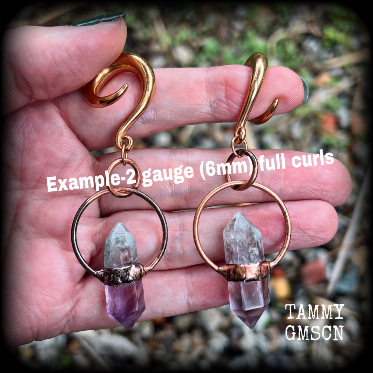 Featuring a pair of beatifully rustic purple fluorite points in an antique copper setting, these gauged earrings measure just over 8cms from tip to tip, and weigh approx 13 grams each.
This pair has been made on 2 gauge (6mm) surgical steel full curl hooks, suitable for stretched lobes.