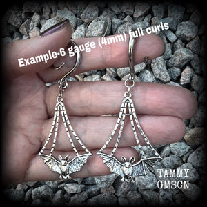 Featuring gorgeous light weight gothic silver bat charms, these spooky cute gauged earrings weigh in at 7 grams a piece, and measure just over 7cms from tip to tip.

This pair has been made on 6 gauge (4mm) surgical steel full curl hooks, to be worn in stretched lobes.