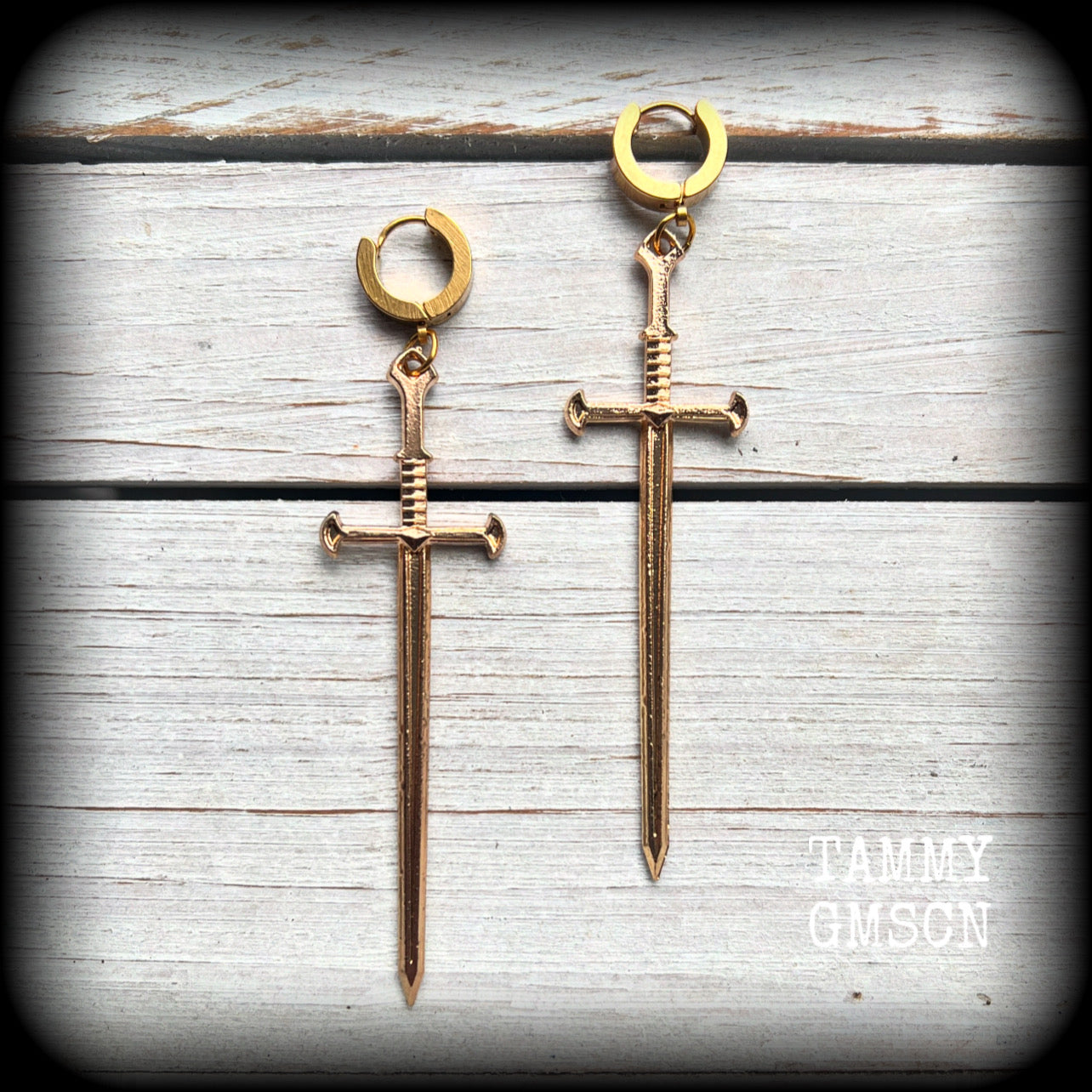 These awesome dangly antique gold sword earrings are nice and lightweight at 7 grams each, and measure in at just under 9cms from tip to tip.
This pair have been made on stainless steel huggie ear cuffs, suitable for pierced ears.