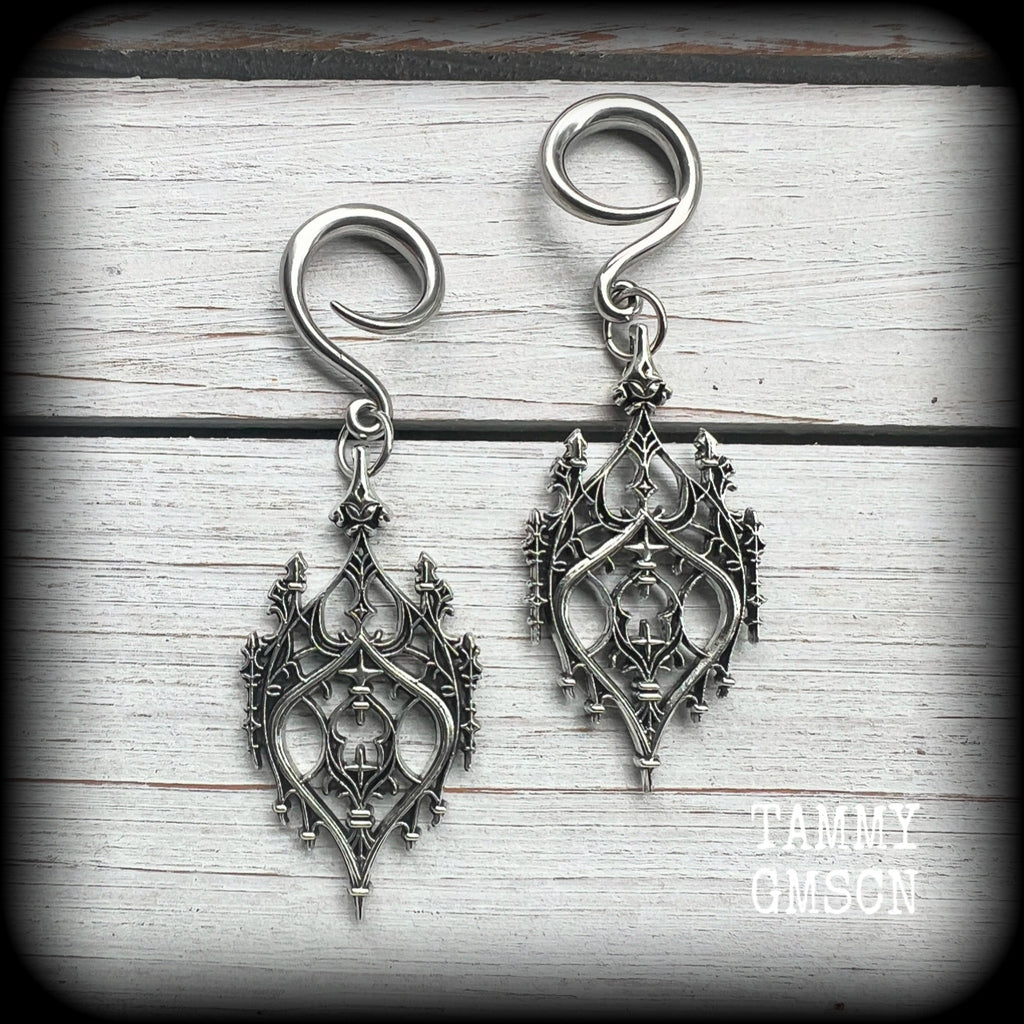 These gorgeous gothic ear hangers feature a beautiful antique silver ornate gothic cathedral chandelier, measuring just on 8cms from tip to tip, and weighing approx 10 grams each.
This pair has been made on 6 gauge (4mm) surgical steel full curls, to be worn in stretched lobes.
