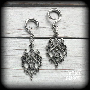These gorgeous gothic ear hangers feature a beautiful antique silver ornate gothic cathedral chandelier, measuring just on 8cms from tip to tip, and weighing approx 10 grams each.
This pair has been made on 6 gauge (4mm) surgical steel full curls, to be worn in stretched lobes.