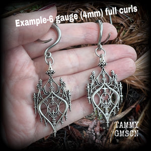 These gorgeous gothic ear hangers feature a beautiful antique silver ornate gothic cathedral chandelier, measuring just on 8cms from tip to tip, and weighing approx 10 grams each. This pair has been made on 6 gauge (4mm) surgical steel full curls.