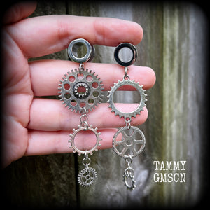 Featuring dangly mismatched antique silver cogs, these steampunk inspired gauged earrings weigh in at only 9 grams a piece, and are nice and dangly at 9cms from tip to tip.
This pair has been made on 00 gauge (10mm) surgical steel screw fit tunnels, to be worn in stretched lobes.