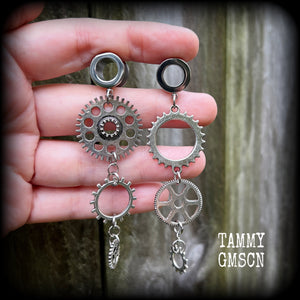 Featuring dangly mismatched antique silver cogs, these steampunk inspired gauged earrings weigh in at only 9 grams a piece, and are nice and dangly at 9cms from tip to tip.
This pair has been made on 00 gauge (10mm) surgical steel screw fit tunnels, to be worn in stretched lobes.