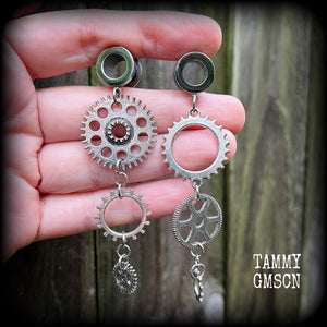 Featuring dangly mismatched antique silver cogs, these steampunk inspired gauged earrings weigh in at only 9 grams a piece, and are nice and dangly at 9cms from tip to tip.
This pair has been made on 00 gauge (10mm) surgical steel screw fit tunnels, to be worn in stretched lobes.