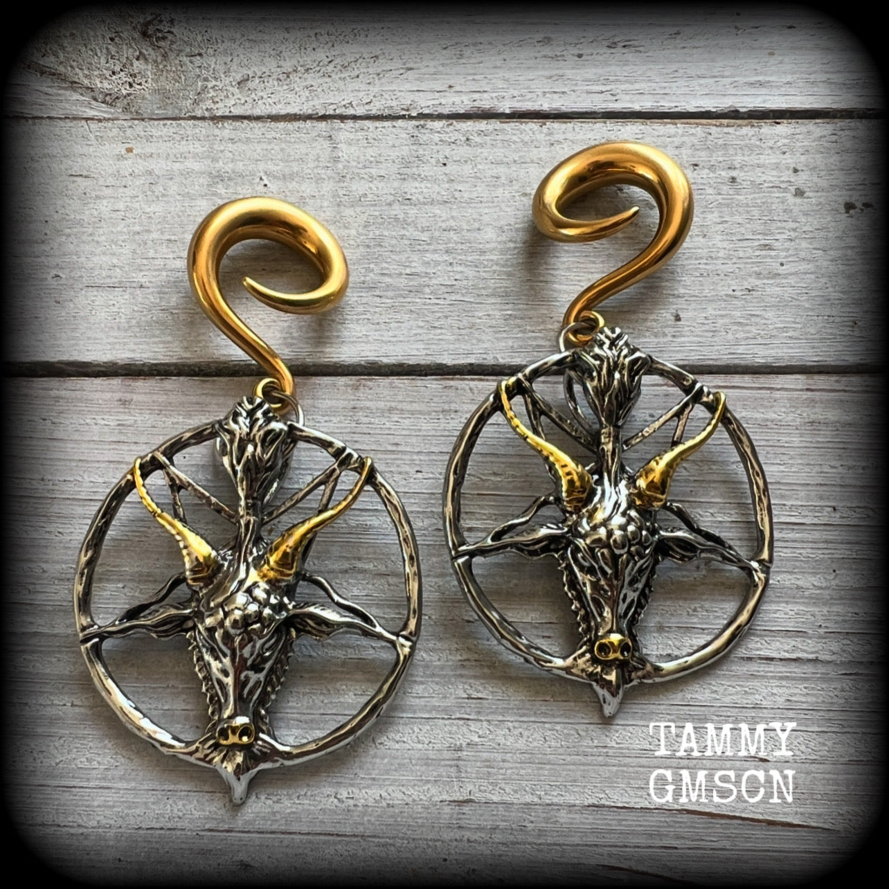These gorgeous antique silver and gold Baphomet gauged earrings and are nice and dangly and nice and big, measuring 8cms from tip to tip, but not too heavy at only 16 grams each.

This pair has been made on 2 gauge (6mm) surgical steel full curl hooks, to be worn in stretched lobes..