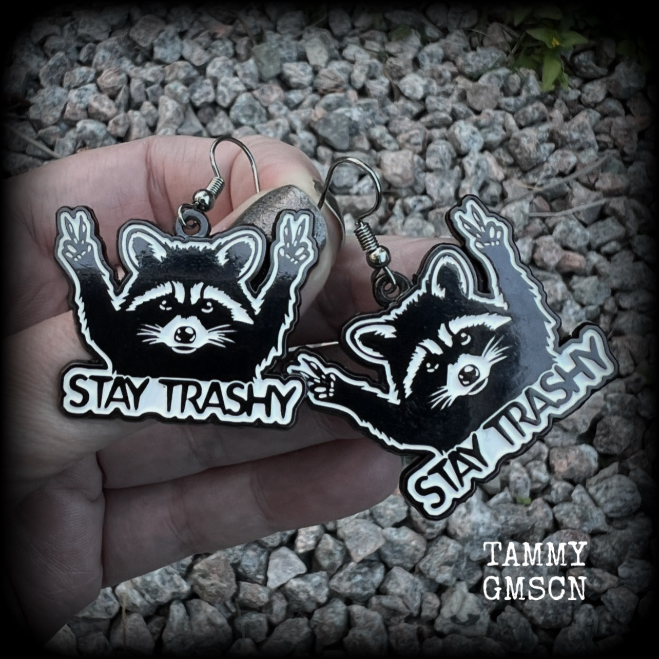 These awesome ‘Stay trashy’ earrings feature a classic raccoon trash panda throwing up V for victory hand signs, measuring in at just under 5 cms from tip to tip and weighing approx 6 grams a piece.

This pair have been made with stainless steel french hooks, suitable for pierced ears.