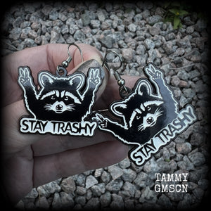These awesome ‘Stay trashy’ earrings feature a classic raccoon trash panda throwing up V for victory hand signs, measuring in at just under 5 cms from tip to tip and weighing approx 6 grams a piece.

This pair have been made with stainless steel french hooks, suitable for pierced ears.