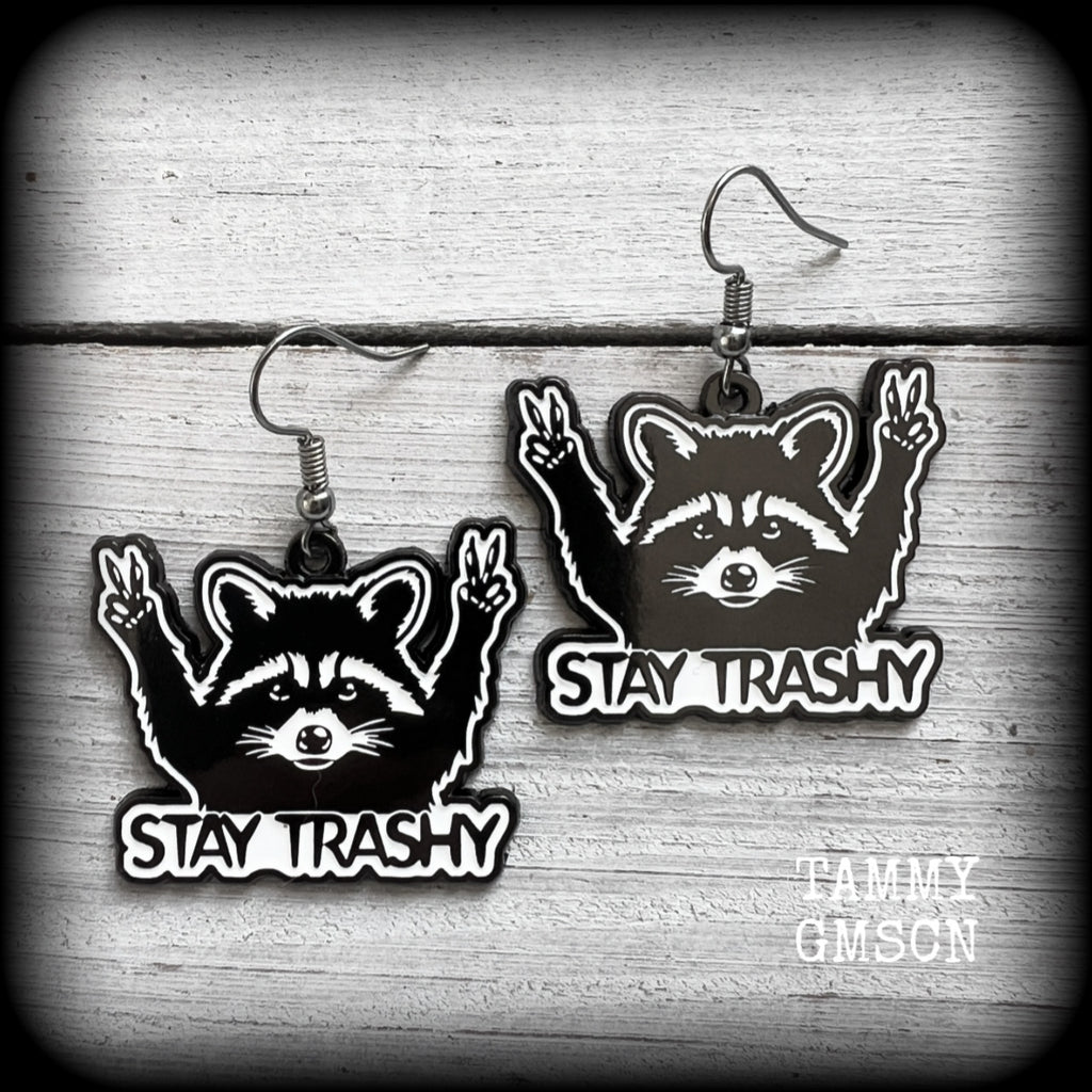 These awesome ‘Stay trashy’ earrings feature a classic raccoon trash panda throwing up V for victory hand signs, measuring in at just under 5 cms from tip to tip and weighing approx 6 grams a piece.

This pair have been made with stainless steel french hooks, suitable for pierced ears.