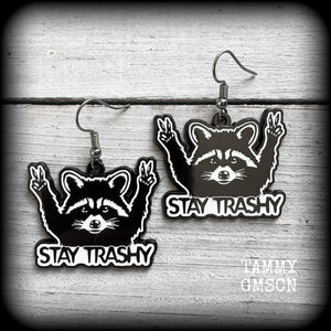 These awesome ‘Stay trashy’ earrings feature a classic raccoon trash panda throwing up V for victory hand signs, measuring in at just under 5 cms from tip to tip and weighing approx 6 grams a piece.

This pair have been made with stainless steel french hooks, suitable for pierced ears.