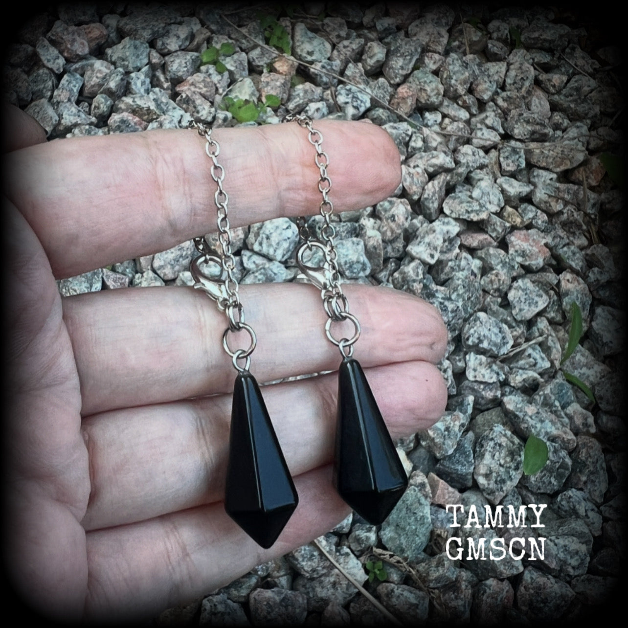 These gorgeous earrings have been made with pitch black obsidian divination pendulums, are nice and light weight at only 5 grams a piece, and are nice and dangly, measuring just over 7cms from tip to tip.

This pair has been made with our super versatile antique silver chain and lobster clasp 4mm option, to be worn through silicone earlets in stretched lobes from 6 gauge (4mm).