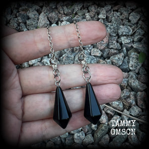 These gorgeous earrings have been made with pitch black obsidian divination pendulums, are nice and light weight at only 5 grams a piece, and are nice and dangly, measuring just over 7cms from tip to tip.

This pair has been made with our super versatile antique silver chain and lobster clasp 4mm option, to be worn through silicone earlets in stretched lobes from 6 gauge (4mm).