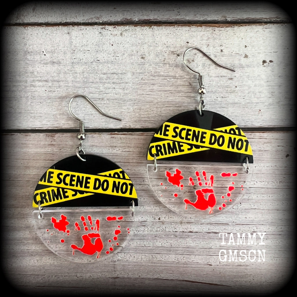 These awesome crime scene inspired earrings feature a bloodied hand print hanging beneath a cautionary crime scene sign, measuring approx 6.5cms from tip to tip and weighing only a few grams each.

This pair has been made with stainless steel french hooks, suitable for pierced ears.