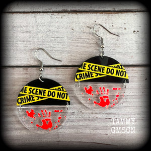 These awesome crime scene inspired earrings feature a bloodied hand print hanging beneath a cautionary crime scene sign, measuring approx 6.5cms from tip to tip and weighing only a few grams each.

This pair has been made with stainless steel french hooks, suitable for pierced ears.